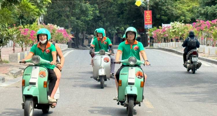 Groupe de personnes en scooter profitant d'une balade dans une zone pittoresque.