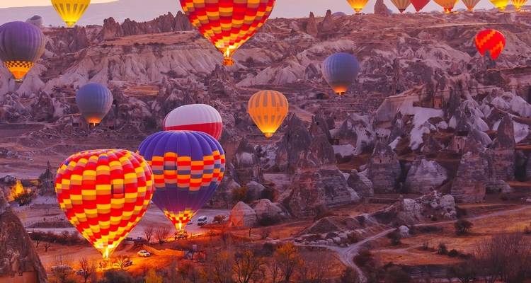Los vibrantes globos aerostáticos iluminan el cielo al amanecer sobre los surrealistas valles de roca de Capadocia.