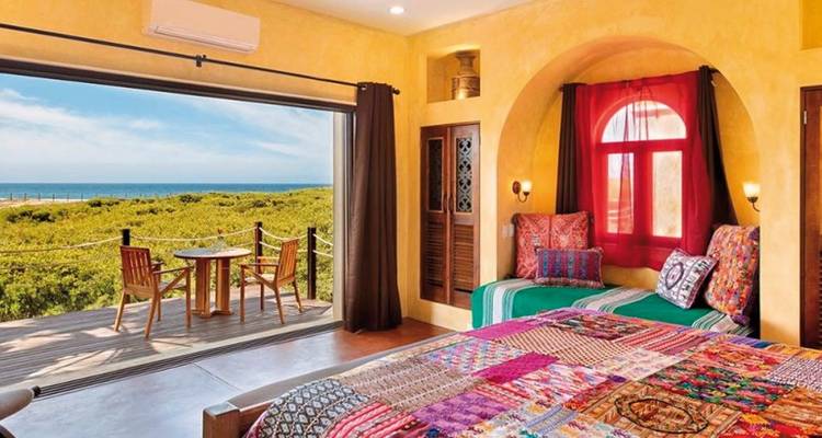 Innenraum eines bunten Hotelzimmers mit Meerblick.