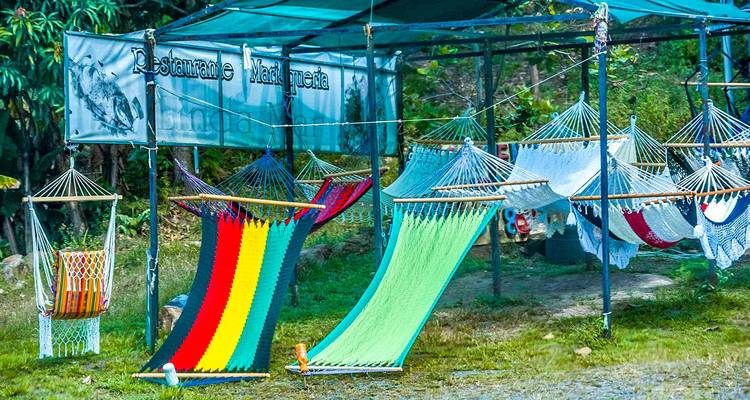Des hamacs colorés exposés dans un étal au bord de la route.