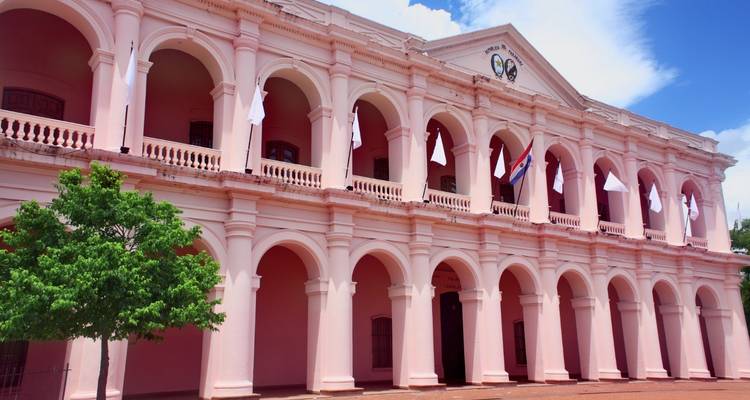 Rosa historisches Gebäude mit Bogenfenstern.