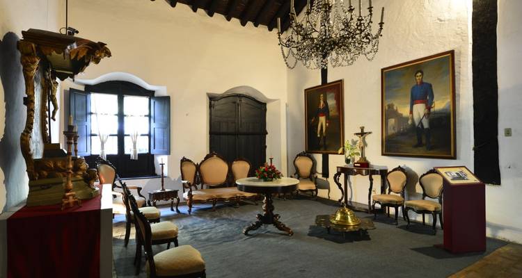 Interieur eines historischen Raumes mit Gemälden und Möbeln.