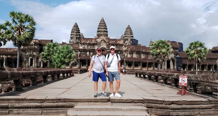 Two tourists standing at the entrance of Angkor Wat.