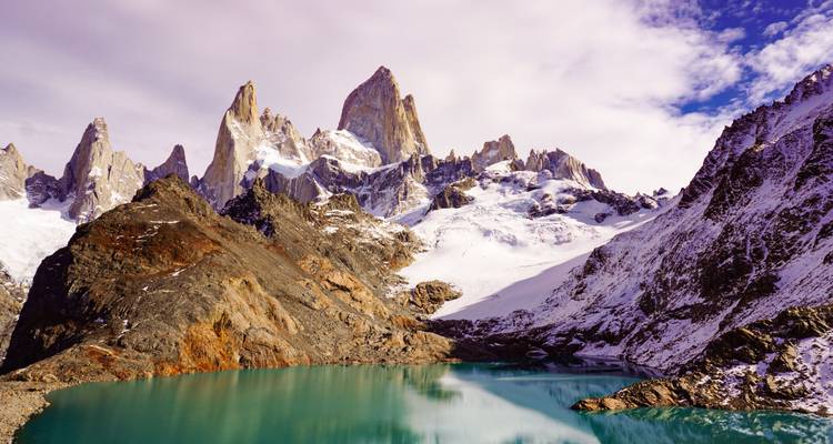 Bergachtig landschap met een meer dat de lucht weerspiegelt.