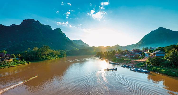 River surrounded by hills and forest in the early morning light