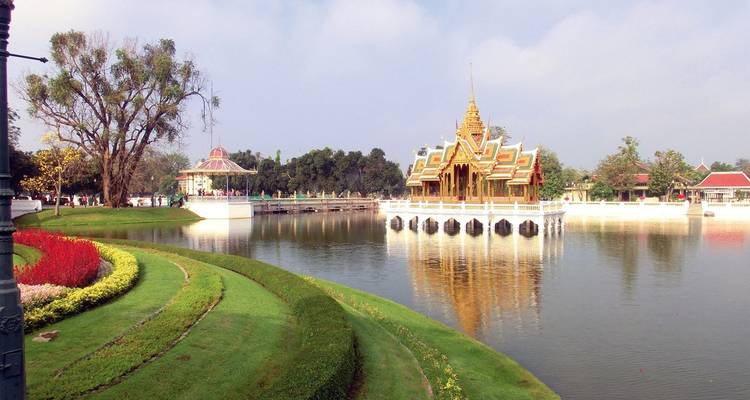 Thailändischer Tempel, der sich in einem friedlichen Gewässer spiegelt.