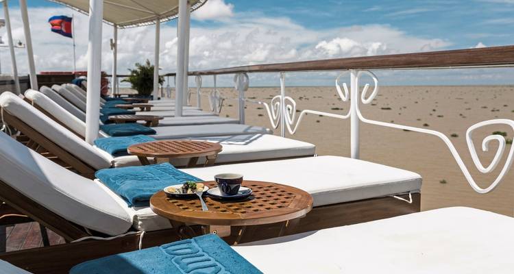Sun loungers and a cup of coffee on a river cruise ship's deck.