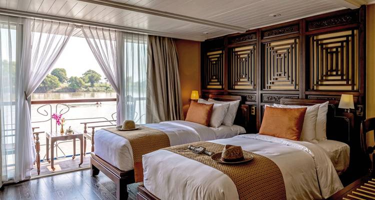 Elegant twin bedroom on a river cruise ship with river view.