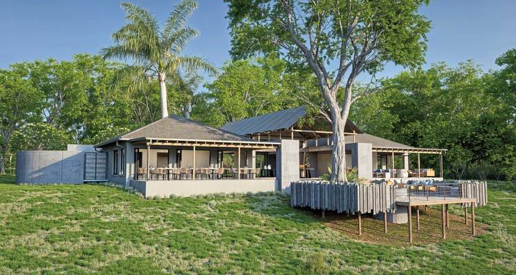 Un lodge moderne entouré d'arbres et d'herbe verte.