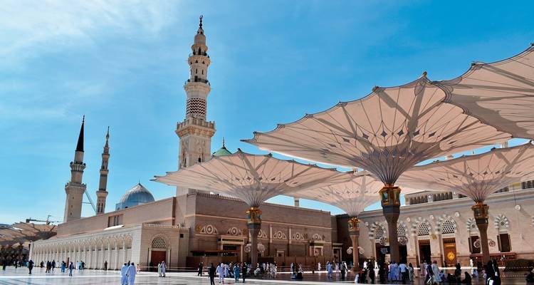 Courtyard of a mosque with a large canopy and minarets.