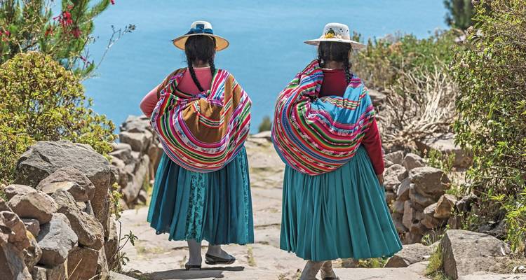 Women in traditional clothing descending stone steps.