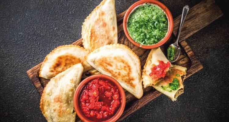 Platte mit Empanadas und Dip-Saucen als Beilage