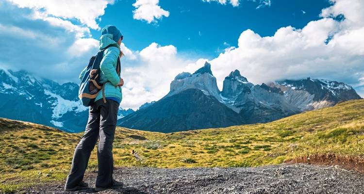 Person in Wanderausrüstung blickt auf die Torres del Paine Berge