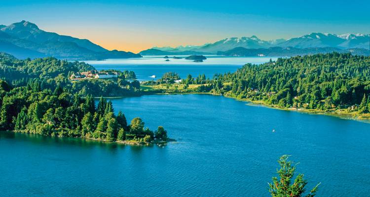 Von Wäldern bewachsenen Bergen und Grün umgebener See