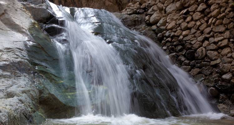 Waterfall cascading against rocky terrain.