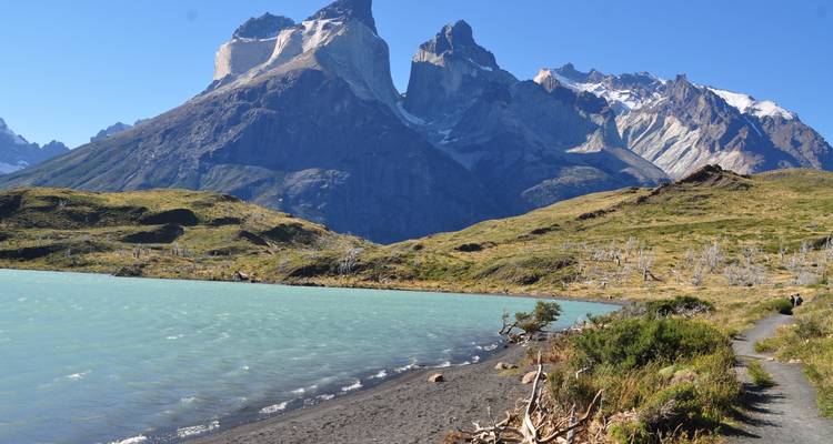 Un lago tranquilo bordeado de montañas bajo un cielo despejado.