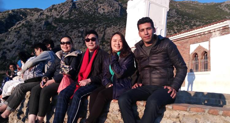Group of people sitting on a wall enjoying the view.