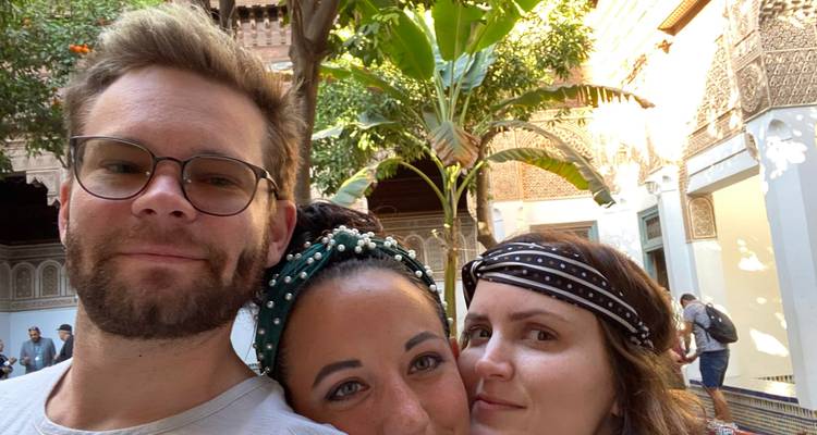 Three people posing in a scenic courtyard.