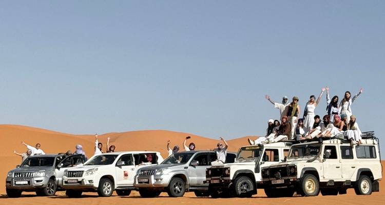 Groep mensen die geniet van een woestijnavontuur met terreinvoertuigen.