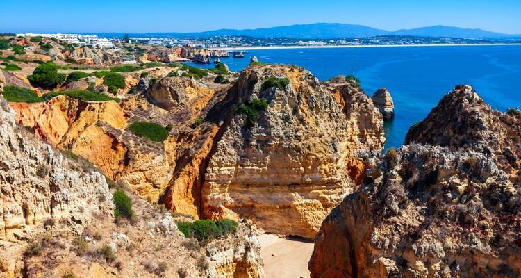Falaises rocheuses spectaculaires surplombant l'océan avec des vues lointaines.