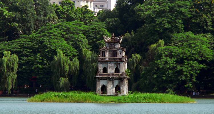 Historische Pagode auf einer Insel in einem See, umgeben von Bäumen.