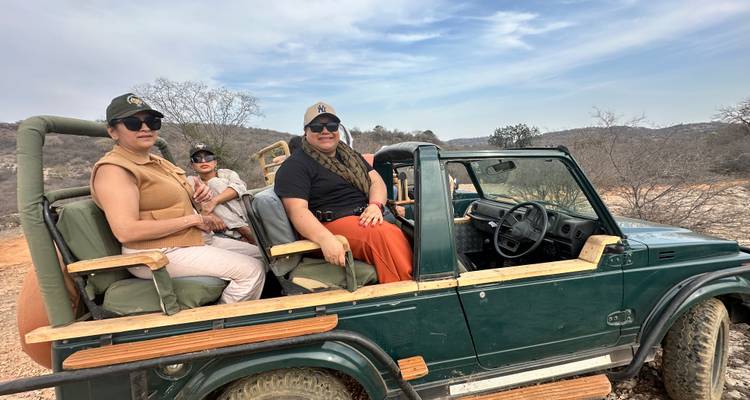 Groep safarideelnemers gezeten in open 4x4 voertuig klaar voor wildlifesafari.