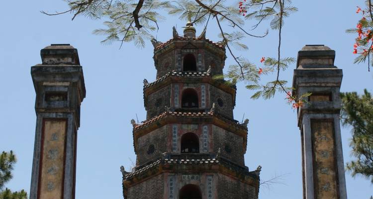Een hoge oude pagode met omringende bomen.