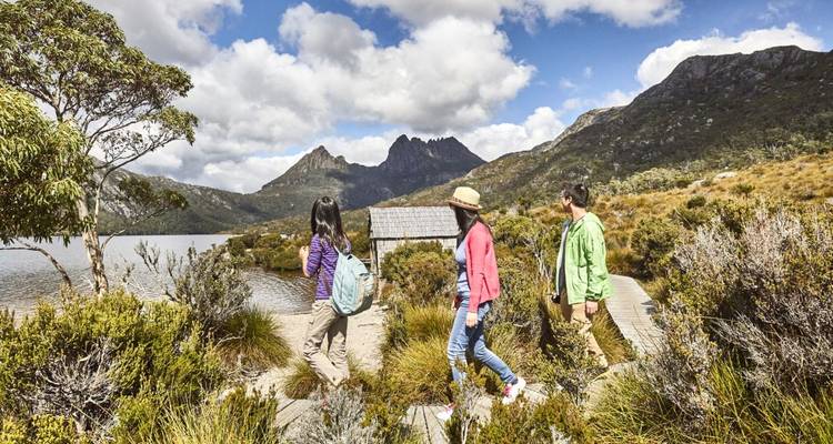 Gruppe von Wanderern, die auf einem Pfad mit Bergen im Hintergrund wandeln.