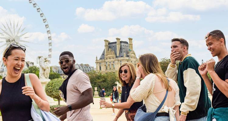 Groupe d'amis qui rient et font du tourisme près d'un monument historique.