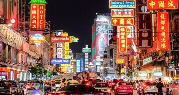 Drukke stadsstraat met neonreclames 's nachts.