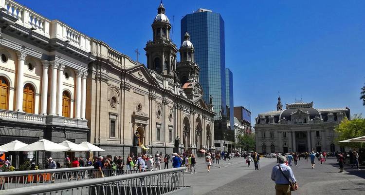 Een bruisend stadsplein met historische gebouwen onder een heldere hemel.