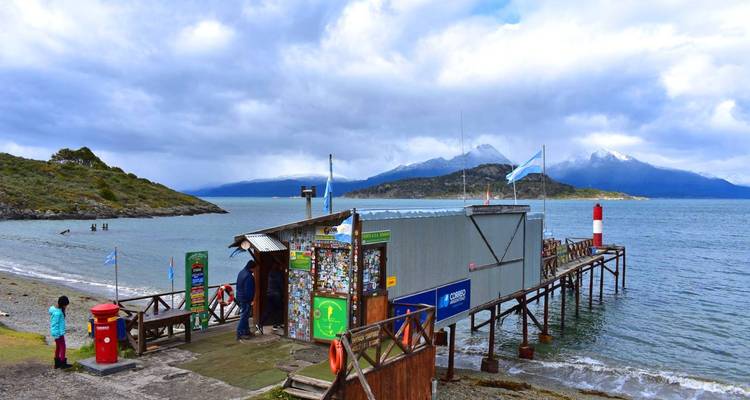 Een kleine steiger en schuur met een berg- en meerachtergrond.