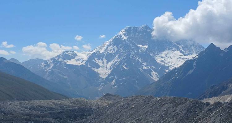 Berggipfel mit Schnee bedeckt unter einem bewölkten Himmel.