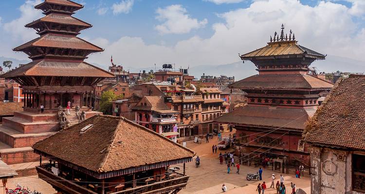 Templos históricos con techos de pagoda y edificios de ladrillo de la Plaza Durbar de Bhaktapur llena de gente local