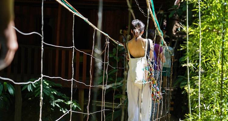 Persona caminando por un puente colgante estrecho.