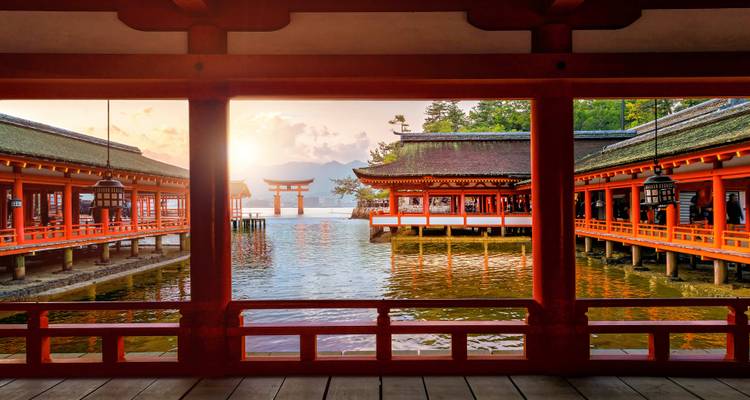 Traditionelle japanische Gebäude mit malerischem Blick auf ein Torii-Tor im Wasser.