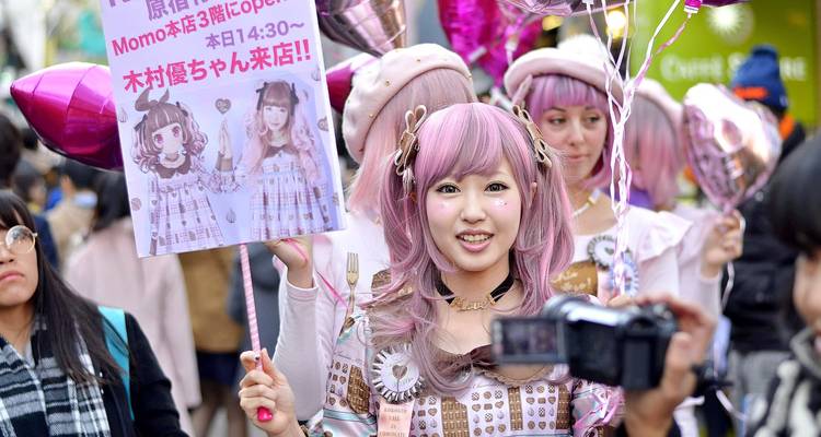 Farbenfroher Straßenumzug mit kostümierten Teilnehmern und Luftballons.