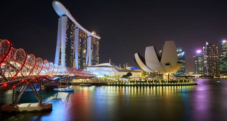 Nachtbeeld van Marina Bay Sands en ArtScience Museum met verlichte stadshorizon en reflecties op het water.