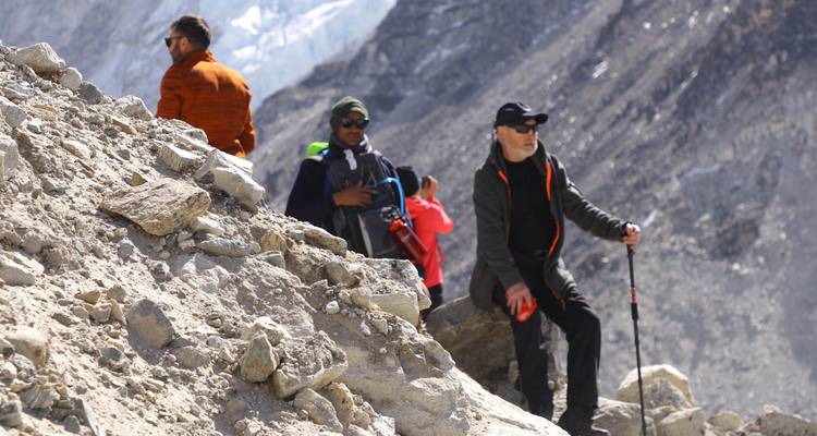 Hikers navigating rocky terrain in a mountainous landscape.