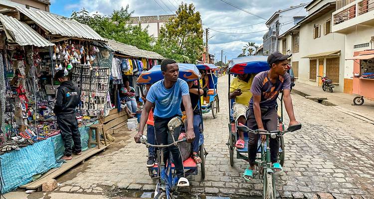 Escena callejera con bicitaxis y vendedores.