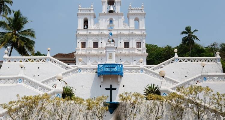 Weiße Kirche mit Treppe und Palmen.
