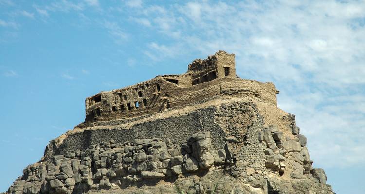 Alte Festung auf einem felsigen Hügel mit einem klaren blauen Himmel.