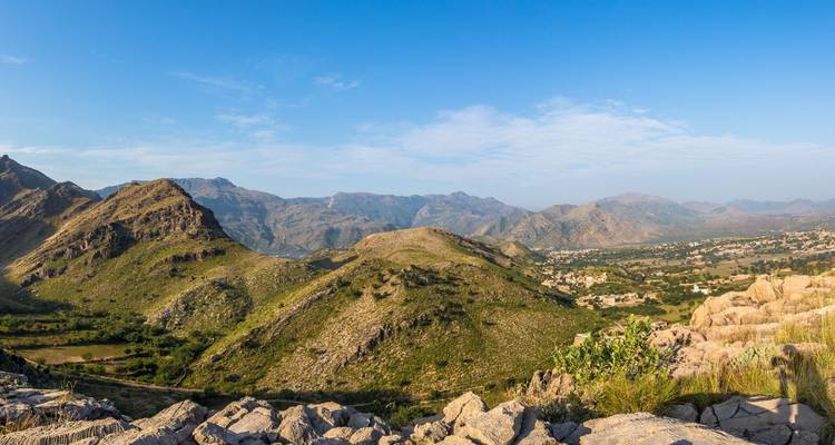 Panoramablick auf eine grüne Berglandschaft.