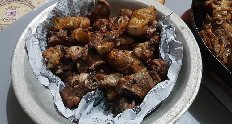 Gekochtes Fleisch serviert in einer Metallschale, die mit Papier ausgelegt ist.