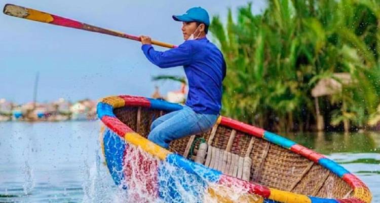 Man roeit in een ronde boot op een rivier.