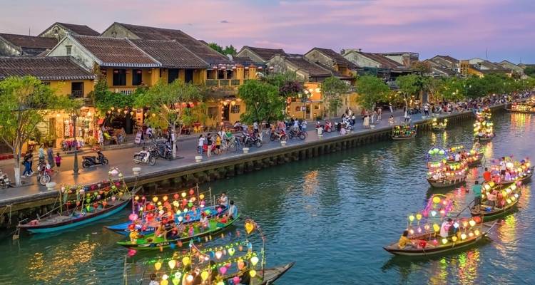 Kleurrijke lantaarns op boten in een rivier tijdens een festival.