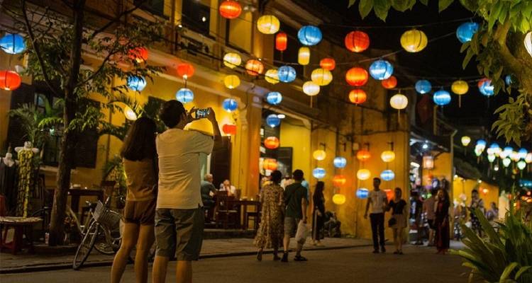 Lantaarnverlichte straat in een bruisende nachtmarkt.