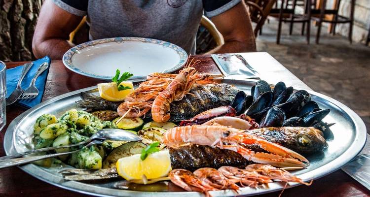 Plateau de fruits de mer avec une personne en arrière-plan dans un restaurant.