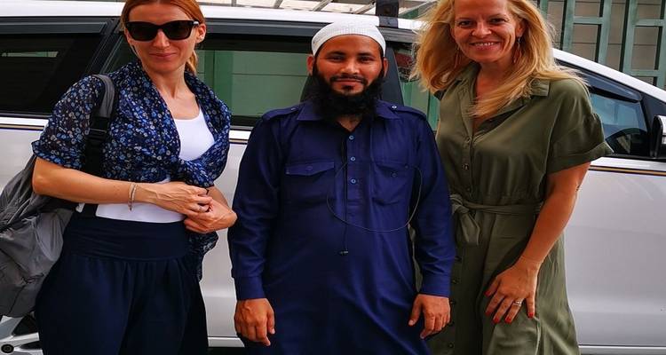 Trois personnes posant pour une photo à côté d'une voiture