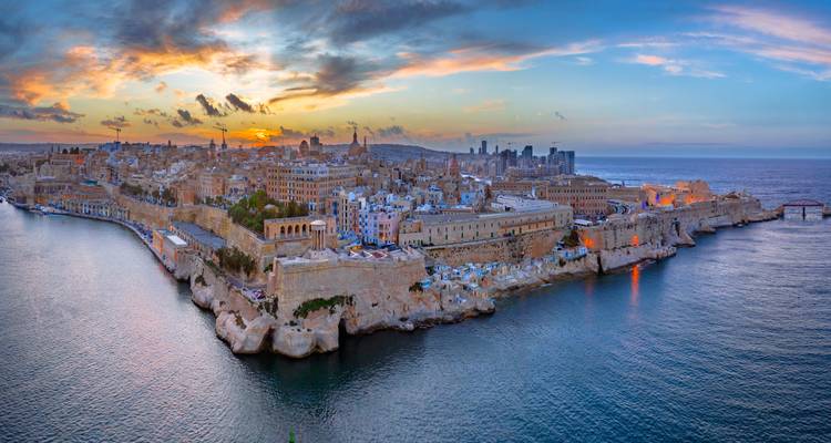 Aerial panoramic view of a historic city at sunset.